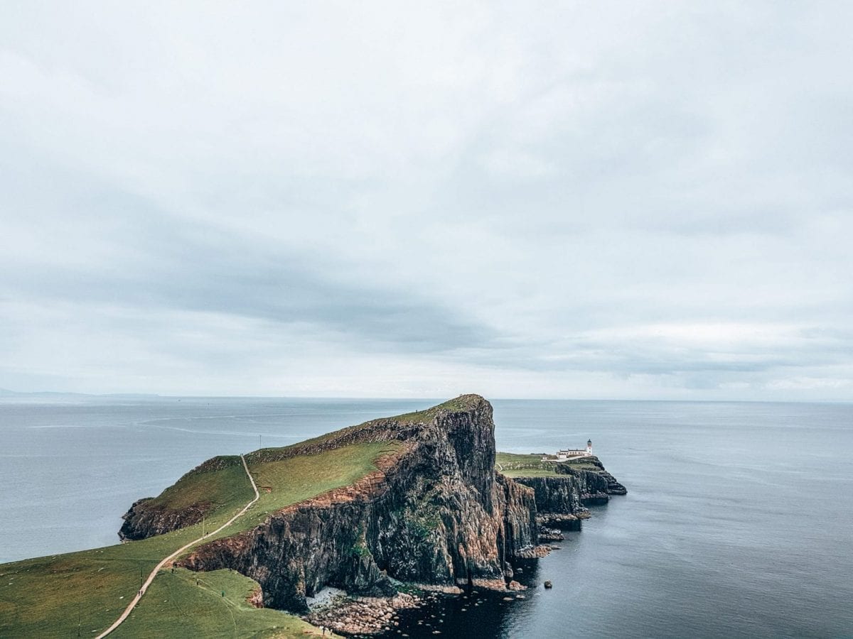lighthouse on a cliff in front of the sea in scotland