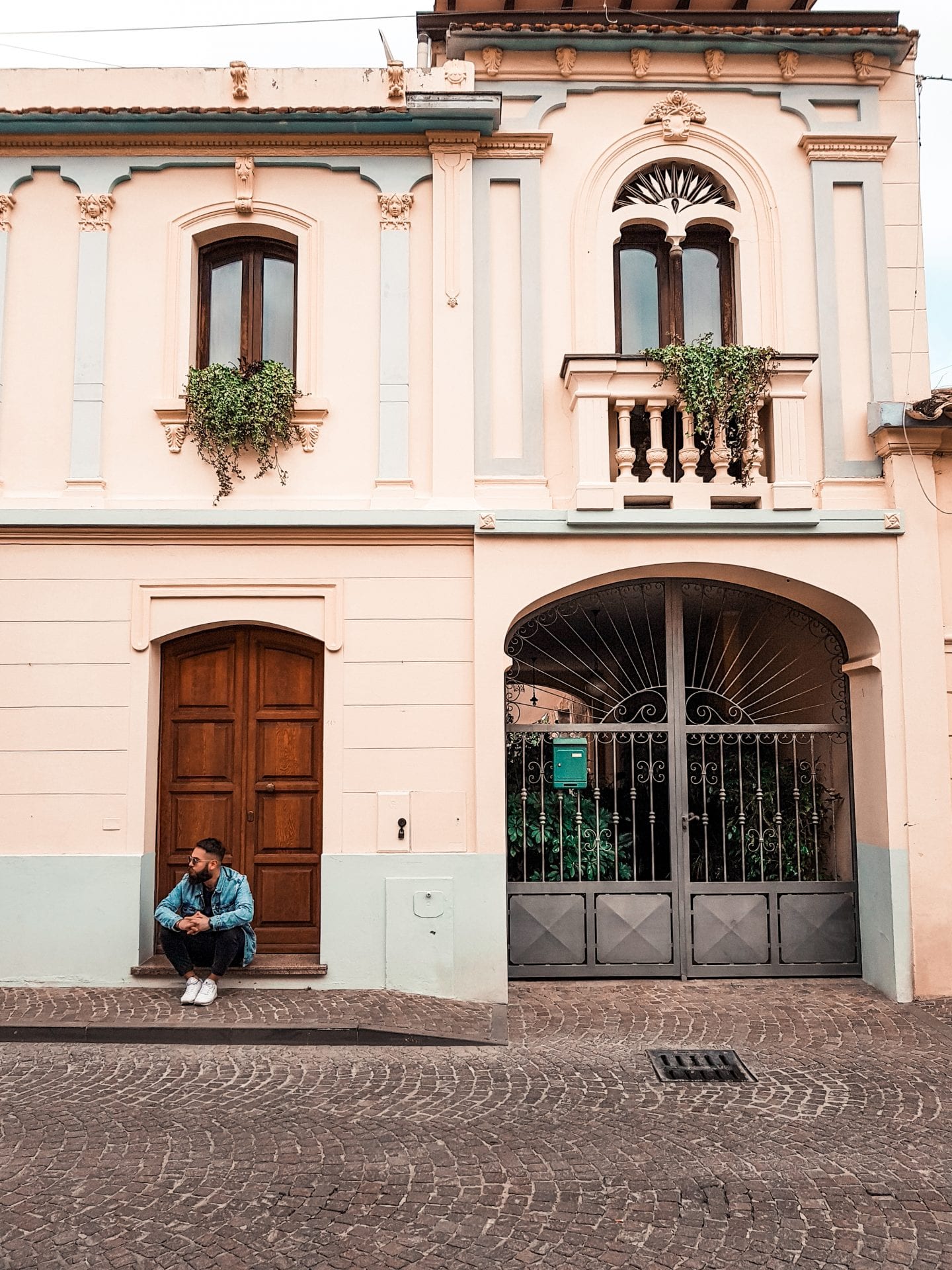 boy sitting in front of an house in italy