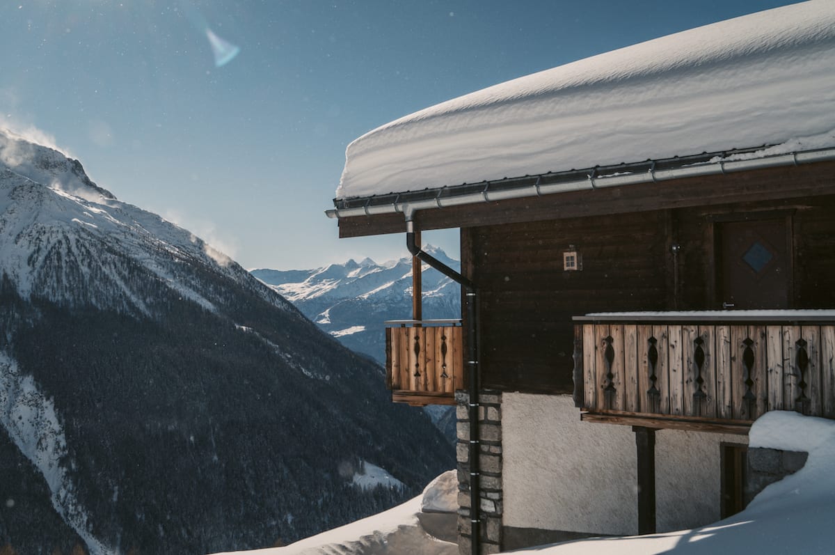Haus vor einem Panoramaausblick mit schneebedeckten Gipfeln im Lötschental